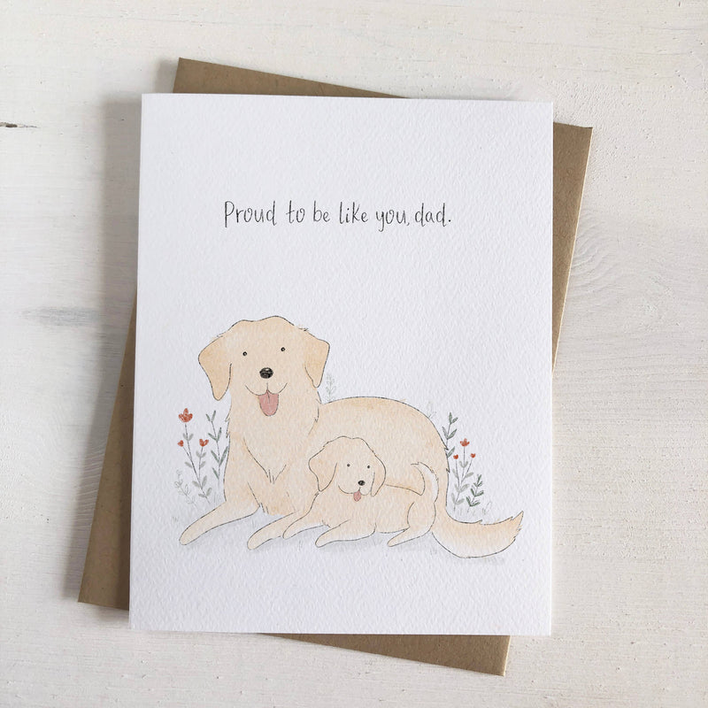 Golden love radiates from this card featuring a papa golden retriever and his puppy. The hand-lettered text reads, "Proud to be like you, dad."
